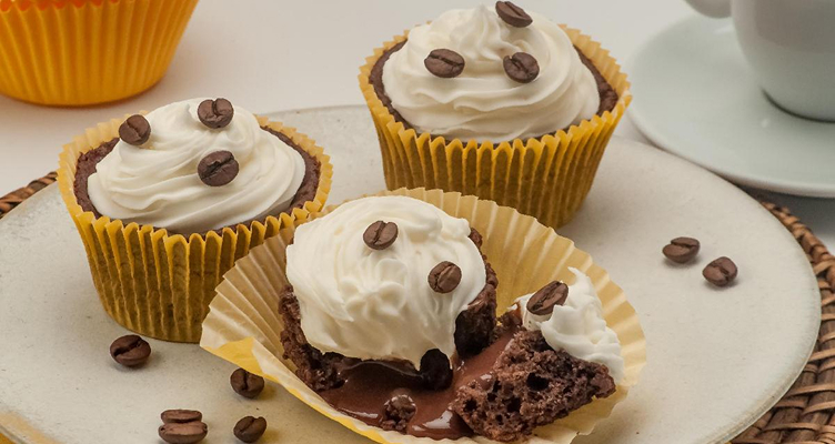 Imagem de um cupcake com grãos de café e chantilly.